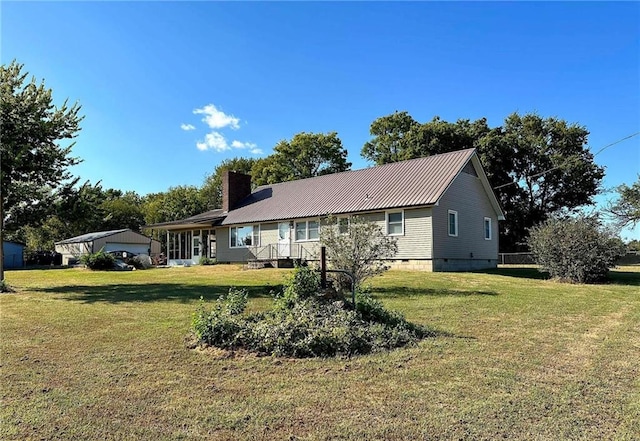 ranch-style house with a front lawn, metal roof, crawl space, and a chimney