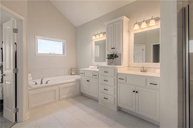 bathroom with a bath, tile patterned floors, vanity, and vaulted ceiling