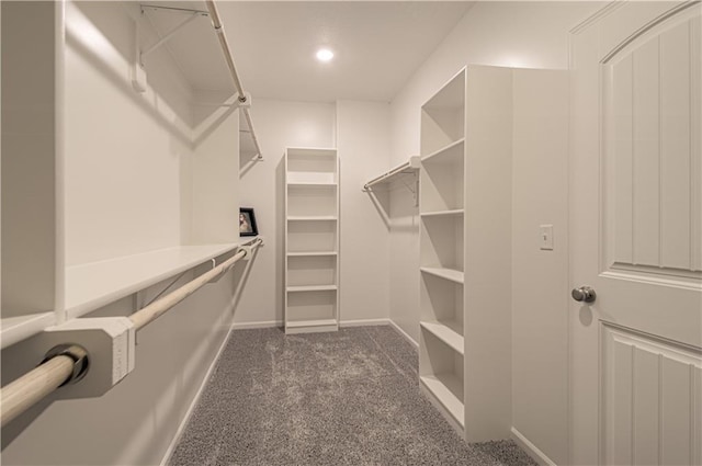 walk in closet featuring dark colored carpet