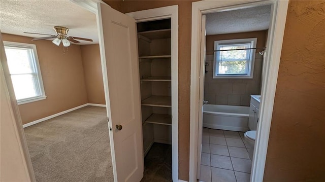 full bathroom with a textured ceiling, tile patterned flooring, toilet, and ceiling fan