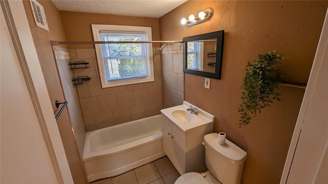 full bathroom featuring a textured ceiling, tiled shower / bath combo, tile patterned floors, vanity, and toilet