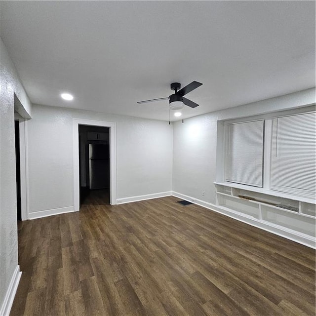 empty room with ceiling fan and dark hardwood / wood-style flooring