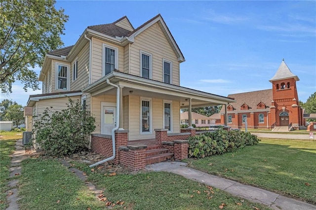 view of front of property with central AC, covered porch, and a front yard