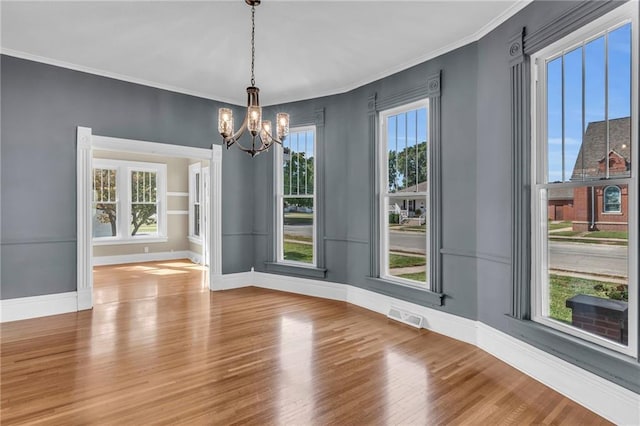 interior space with a notable chandelier, a wealth of natural light, and wood-type flooring