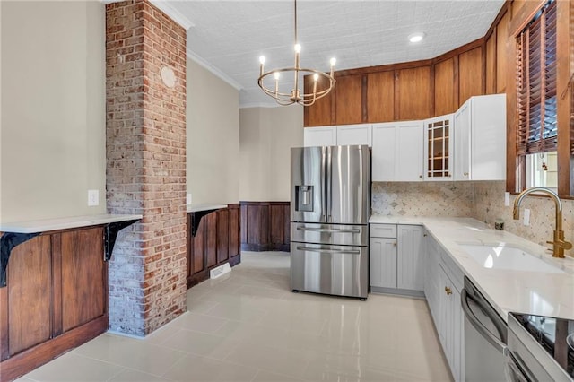 kitchen featuring light tile patterned flooring, white cabinets, stainless steel appliances, sink, and a notable chandelier