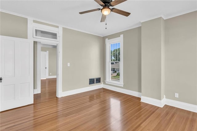 empty room featuring ceiling fan, crown molding, and hardwood / wood-style floors