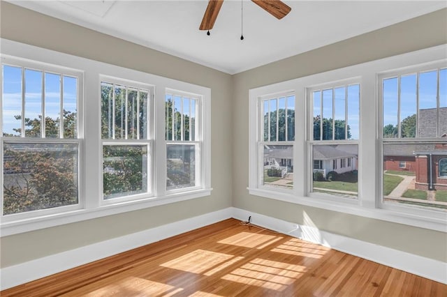 unfurnished sunroom with ceiling fan and plenty of natural light