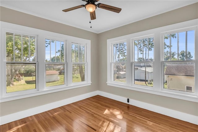 unfurnished room with a wealth of natural light, ceiling fan, and wood-type flooring