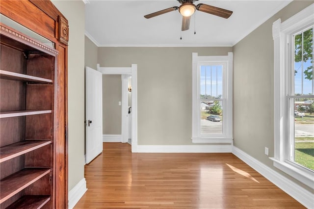 spare room featuring light hardwood / wood-style flooring, ceiling fan, and crown molding