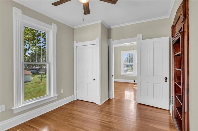 unfurnished bedroom with crown molding, ceiling fan, light hardwood / wood-style flooring, and a closet