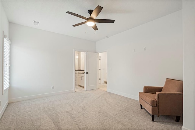 living area with light carpet and ceiling fan