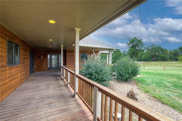 wooden deck with a rural view and a lawn