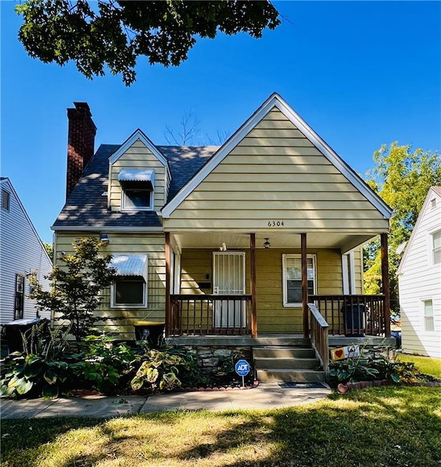 view of front of house featuring covered porch and a front yard