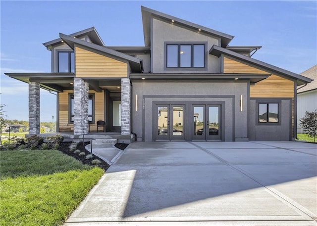 view of exterior entry featuring french doors and a lawn