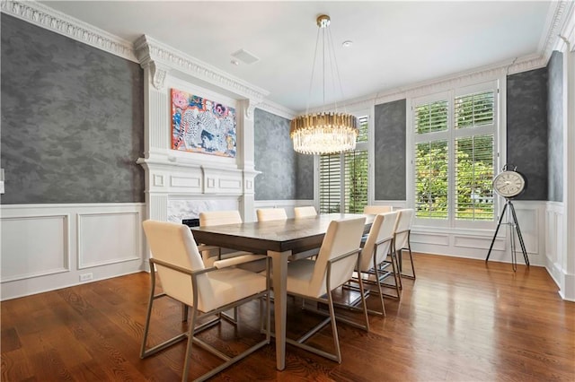 dining space featuring a fireplace, dark hardwood / wood-style floors, a chandelier, and ornamental molding