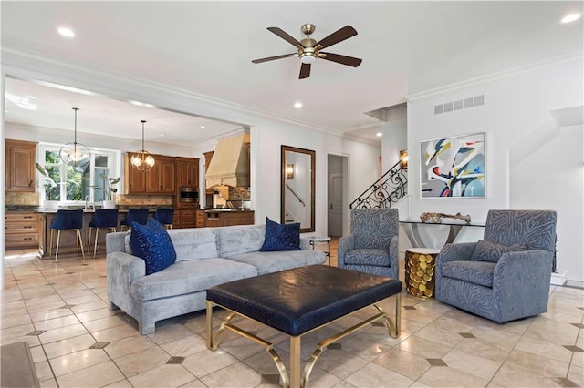 living room featuring light tile patterned flooring, ceiling fan with notable chandelier, and ornamental molding