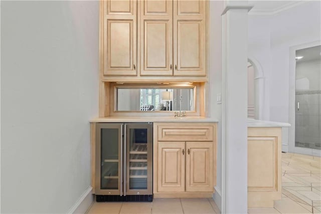 bar with beverage cooler, ornamental molding, and light tile patterned floors