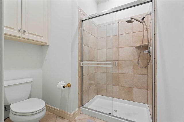 bathroom featuring tile patterned floors, a shower with shower door, and toilet