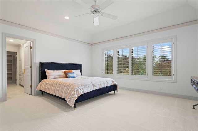 bedroom with ceiling fan, light colored carpet, and ensuite bathroom