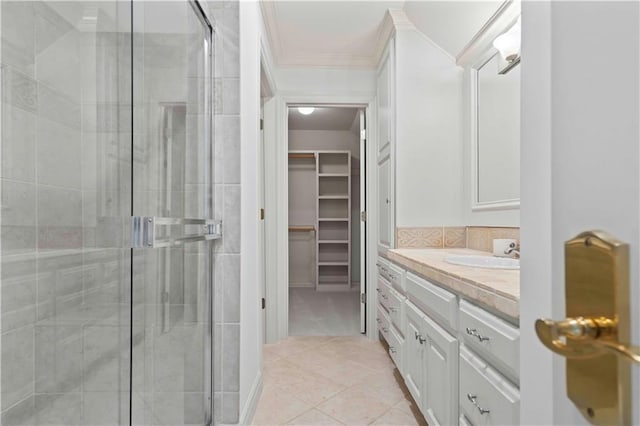 bathroom with tile patterned floors, crown molding, vanity, and a shower with shower door