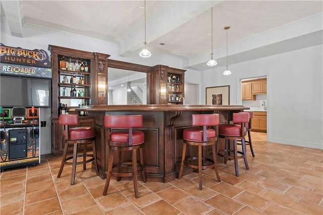 bar with light brown cabinets, beamed ceiling, hanging light fixtures, and crown molding