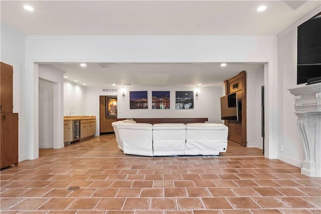 living room with indoor wet bar, wine cooler, and ornamental molding