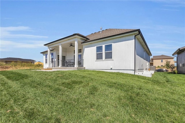 back of house featuring ceiling fan, a lawn, and central AC unit