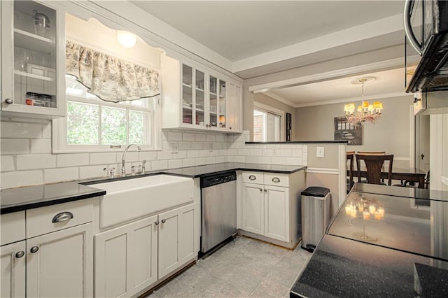 kitchen with hanging light fixtures, backsplash, sink, white cabinets, and appliances with stainless steel finishes