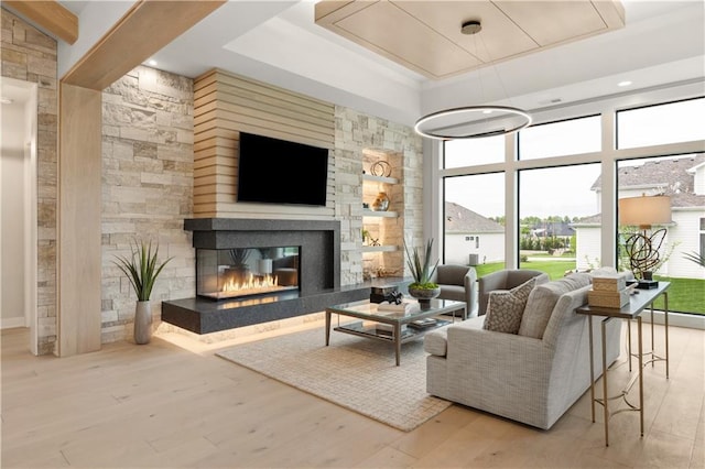 12303 W 167th Ter, Overland Park, KS 66221 - living room featuring a tray ceiling, a glass covered fireplace, and wood finished floors