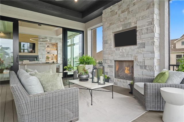 12303 W 167th Ter, Overland Park, KS 66221 - living area with an outdoor stone fireplace, wood finished floors, and a tray ceiling