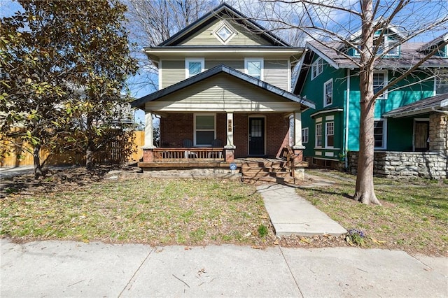 view of front of property featuring covered porch and a front lawn