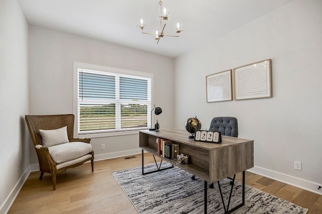 office space featuring an inviting chandelier and light wood-type flooring