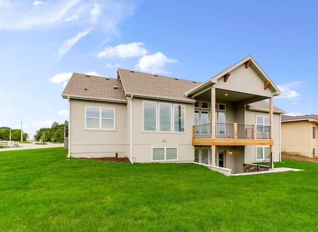 back of property with a balcony and a yard