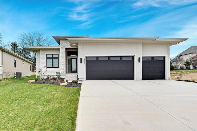 view of front of house with a garage, a front lawn, and central air condition unit