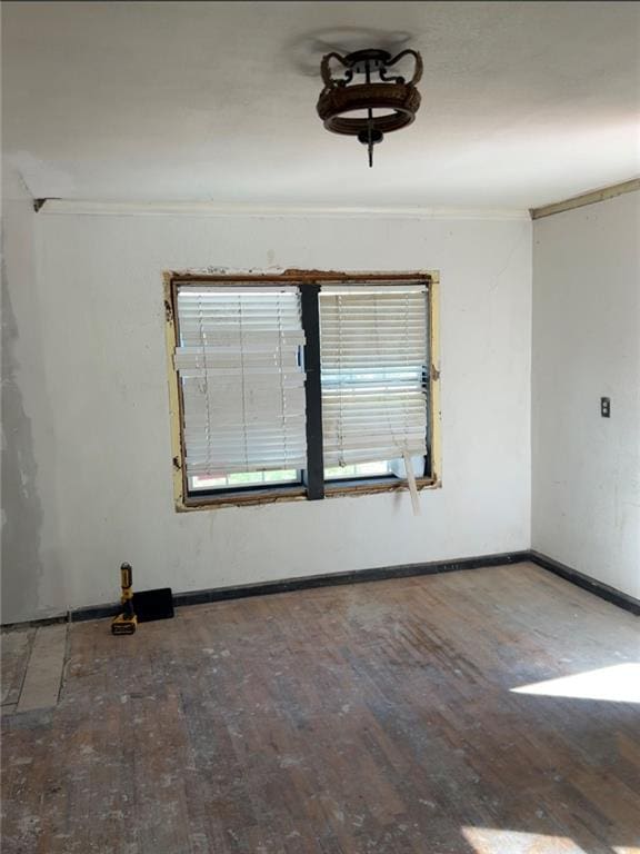 empty room featuring hardwood / wood-style floors and crown molding