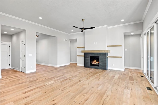 unfurnished living room featuring light wood-type flooring, a warm lit fireplace, ceiling fan, and baseboards