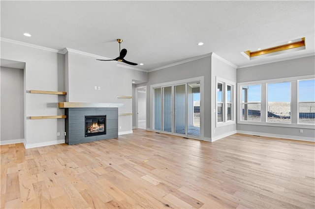 unfurnished living room featuring a ceiling fan, a tile fireplace, light wood-style flooring, and baseboards