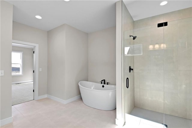 bathroom with a stall shower, a freestanding tub, baseboards, and recessed lighting