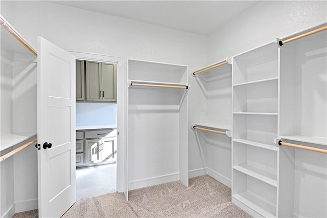 walk in closet featuring light carpet