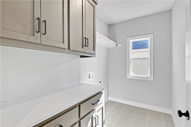 laundry area with tile patterned flooring, hookup for a washing machine, baseboards, cabinet space, and electric dryer hookup