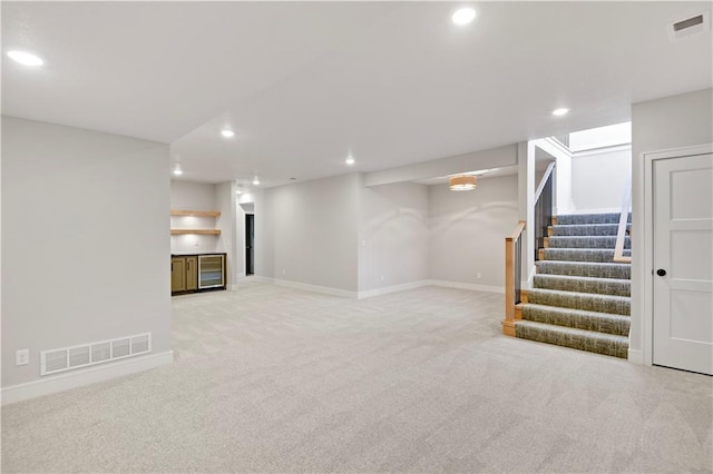 finished basement with recessed lighting, visible vents, and stairway