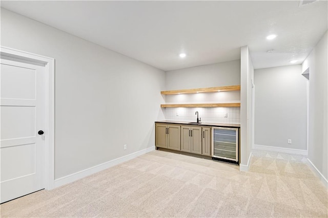 bar with beverage cooler, indoor wet bar, a sink, and light colored carpet