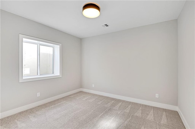 carpeted empty room featuring visible vents and baseboards