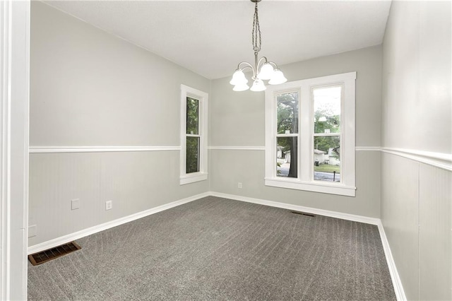 empty room featuring carpet and a chandelier