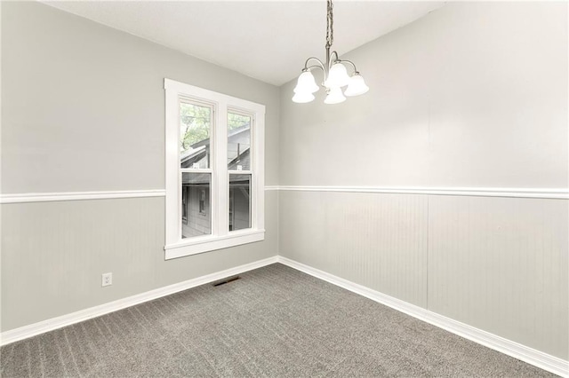 unfurnished room featuring carpet flooring and an inviting chandelier