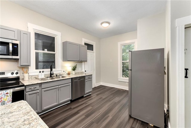 kitchen featuring gray cabinets, appliances with stainless steel finishes, dark wood-type flooring, and sink