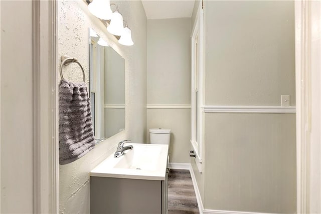 bathroom featuring vanity, toilet, and hardwood / wood-style flooring