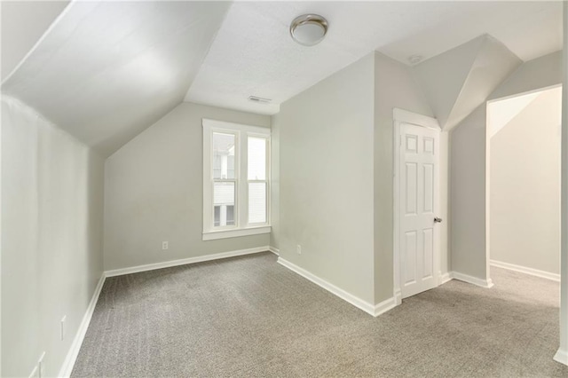 bonus room with carpet flooring and vaulted ceiling