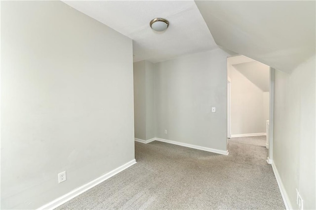 additional living space featuring lofted ceiling and light carpet