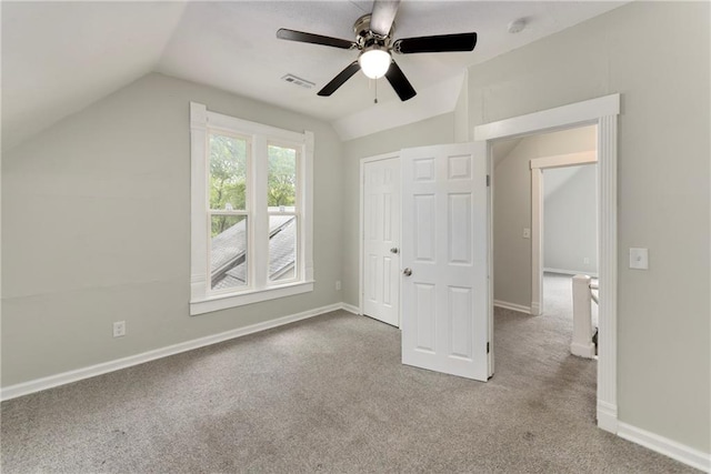 unfurnished bedroom featuring carpet flooring, vaulted ceiling, ceiling fan, and a closet